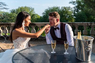 Salle de réception décorée avec des tables rondes recouvertes de nappes rouges, ornées de compositions florales.