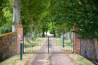 Salle de réception décorée avec des tables rondes recouvertes de nappes rouges, ornées de compositions florales.