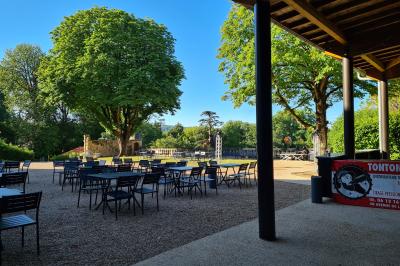 Salle de réception décorée avec des tables rondes recouvertes de nappes rouges, ornées de compositions florales.