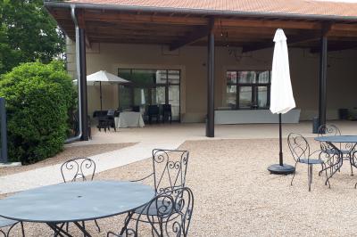 Salle de réception décorée avec des tables rondes recouvertes de nappes rouges, ornées de compositions florales.