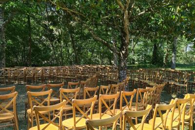 Salle de réception décorée avec des tables rondes recouvertes de nappes rouges, ornées de compositions florales.