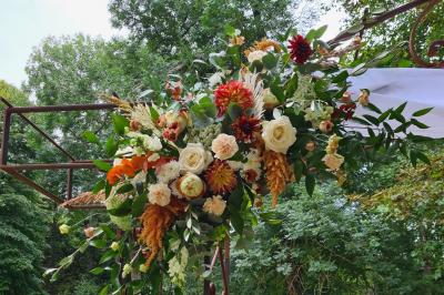 Salle de réception décorée avec des tables rondes recouvertes de nappes rouges, ornées de compositions florales.