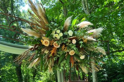 Salle de réception décorée avec des tables rondes recouvertes de nappes rouges, ornées de compositions florales.