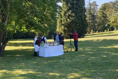 Salle de réception décorée avec des tables rondes recouvertes de nappes rouges, ornées de compositions florales.