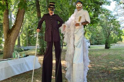 Salle de réception décorée avec des tables rondes recouvertes de nappes rouges, ornées de compositions florales.