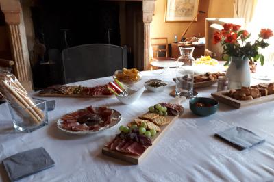 Salle de réception décorée avec des tables rondes recouvertes de nappes rouges, ornées de compositions florales.
