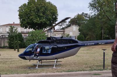 Salle de réception décorée avec des tables rondes recouvertes de nappes rouges, ornées de compositions florales.