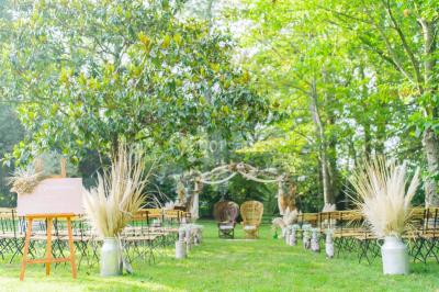 Salle de réception décorée avec des tables rondes recouvertes de nappes rouges, ornées de compositions florales.