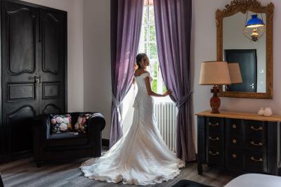 Salle de réception décorée avec des tables rondes recouvertes de nappes rouges, ornées de compositions florales.