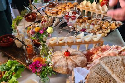 Salle de réception décorée avec des tables rondes recouvertes de nappes rouges, ornées de compositions florales.