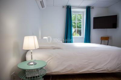 Salle de réception décorée avec des tables rondes recouvertes de nappes rouges, ornées de compositions florales.