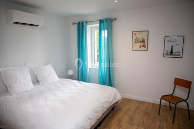 Salle de réception décorée avec des tables rondes recouvertes de nappes rouges, ornées de compositions florales.