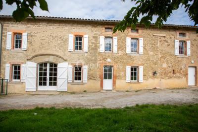 Salle de réception décorée avec des tables rondes recouvertes de nappes rouges, ornées de compositions florales.