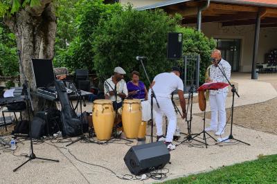 Salle de réception décorée avec des tables rondes recouvertes de nappes rouges, ornées de compositions florales.