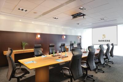 Une personne déguste une tartine garnie d'avocat et saumon, entourée de viennoiseries, fruits et boissons sur une table.