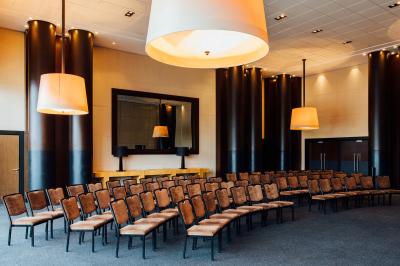 Une personne déguste une tartine garnie d'avocat et saumon, entourée de viennoiseries, fruits et boissons sur une table.