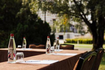 Une personne déguste une tartine garnie d'avocat et saumon, entourée de viennoiseries, fruits et boissons sur une table.