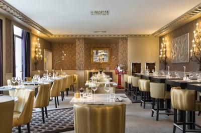 Une personne déguste une tartine garnie d'avocat et saumon, entourée de viennoiseries, fruits et boissons sur une table.