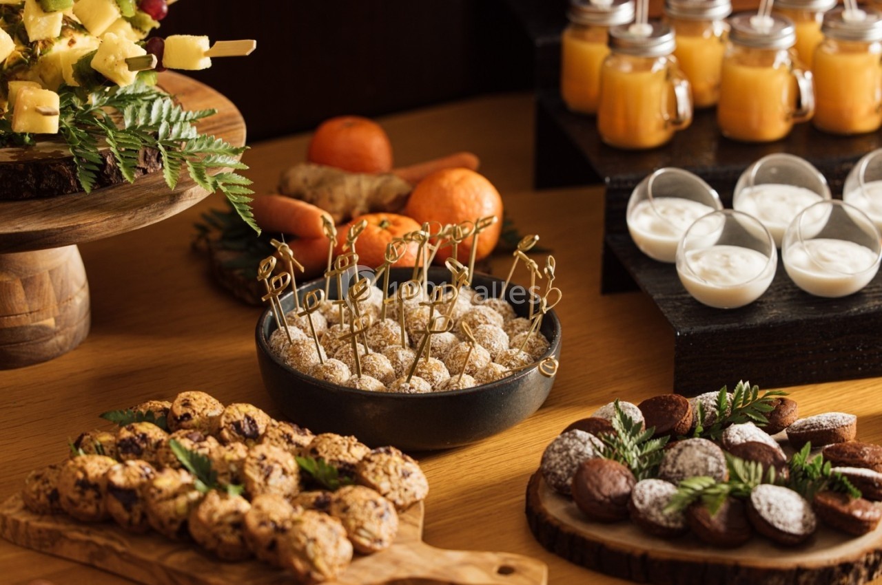 Buffet avec desserts variés, brochettes de fruits, biscuits, truffes et verrines de yaourt et jus.