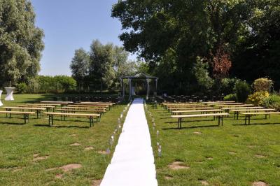 Salle de réception en briques avec tables rondes dressées, nappes blanches et décoration de mariage.
