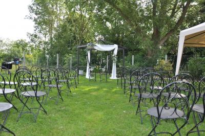 Salle de réception en briques avec tables rondes dressées, nappes blanches et décoration de mariage.