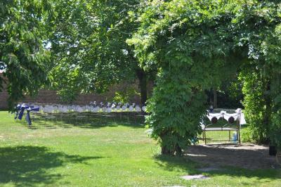 Salle de réception en briques avec tables rondes dressées, nappes blanches et décoration de mariage.