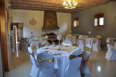 Salle de réception en briques avec tables rondes dressées, nappes blanches et décoration de mariage.