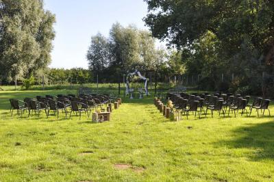 Salle de réception en briques avec tables rondes dressées, nappes blanches et décoration de mariage.