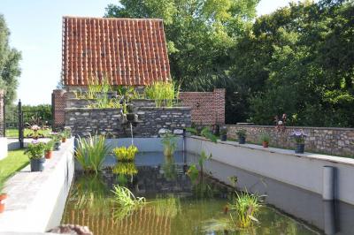Salle de réception en briques avec tables rondes dressées, nappes blanches et décoration de mariage.