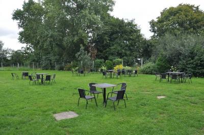 Salle de réception en briques avec tables rondes dressées, nappes blanches et décoration de mariage.