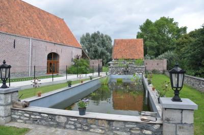 Salle de réception en briques avec tables rondes dressées, nappes blanches et décoration de mariage.