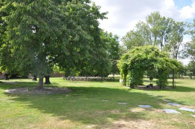Salle de réception en briques avec tables rondes dressées, nappes blanches et décoration de mariage.