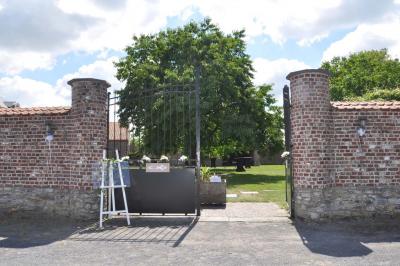 Salle de réception en briques avec tables rondes dressées, nappes blanches et décoration de mariage.