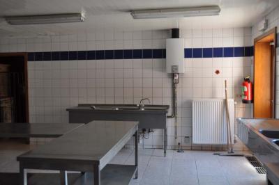 Salle de réception en briques avec tables rondes dressées, nappes blanches et décoration de mariage.