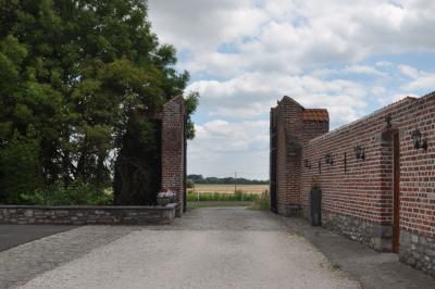 Salle de réception en briques avec tables rondes dressées, nappes blanches et décoration de mariage.