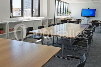Table garnie de petits fours, desserts et plantes décoratives dans une salle lumineuse avec murs blancs.