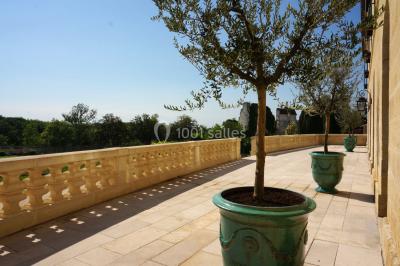 Vue aérienne d'un domaine entouré de vignes, de bâtiments en pierre et d'un cours d'eau bordé de verdure.