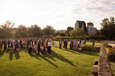 Vue aérienne d'un domaine entouré de vignes, de bâtiments en pierre et d'un cours d'eau bordé de verdure.