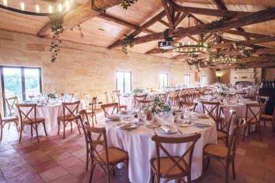 Vue aérienne d'un domaine entouré de vignes, de bâtiments en pierre et d'un cours d'eau bordé de verdure.