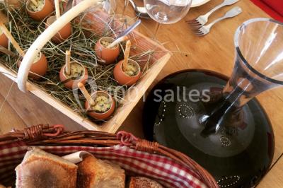 Vue d'un lac entouré d'arbres au lever du soleil, avec des reflets sur l'eau et une légère brume.