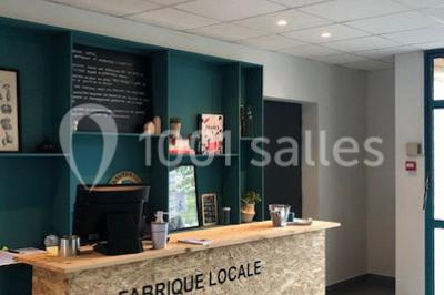 Pelouse verdoyante avec un grand arbre, bâtiment moderne en arrière-plan et ciel dégagé.