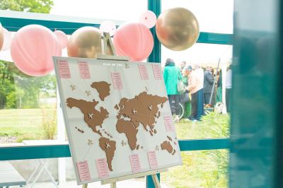 Pelouse verdoyante avec un grand arbre, bâtiment moderne en arrière-plan et ciel dégagé.