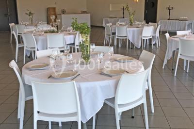 Pelouse verdoyante avec un grand arbre, bâtiment moderne en arrière-plan et ciel dégagé.