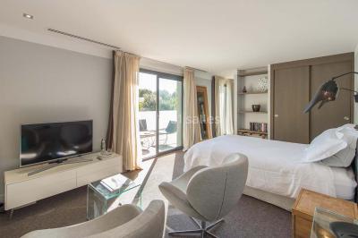 Bâtiment moderne entouré de végétation, avec un chemin pavé et des panneaux indiquant des salles et des logements.