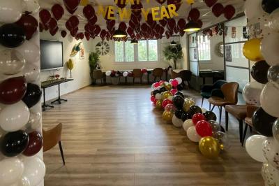 Des personnes assises autour de tables dans une salle lumineuse, partageant un repas ou discutant.