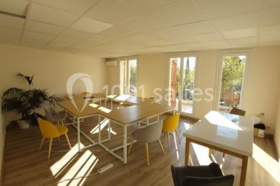 Miniature Location salle La Garde (Var) - City Var #8 Salle de réunion lumineuse avec plusieurs tables, chaises variées, plantes vertes et un écran mural.