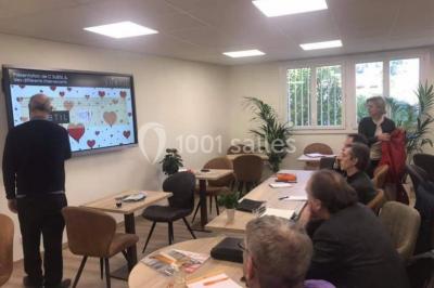 Miniature Location salle La Garde (Var) - City Var #24 Salle de réunion lumineuse avec plusieurs tables, chaises variées, plantes vertes et un écran mural.