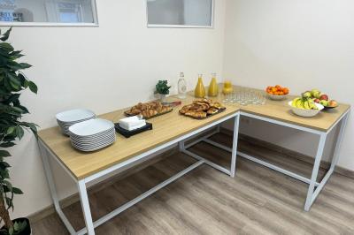 Miniature Location salle La Garde (Var) - City Var #27 Salle de réunion lumineuse avec plusieurs tables, chaises variées, plantes vertes et un écran mural.