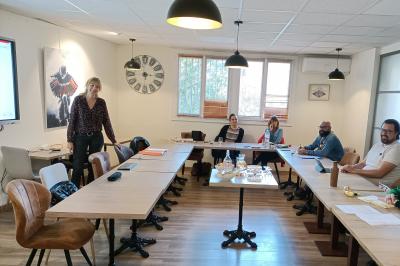 Miniature Location salle La Garde (Var) - City Var #20 Salle de réunion lumineuse avec plusieurs tables, chaises variées, plantes vertes et un écran mural.