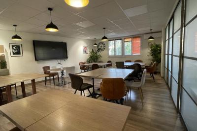 Miniature Location salle La Garde (Var) - City Var #2 Salle de réunion lumineuse avec plusieurs tables, chaises variées, plantes vertes et un écran mural.